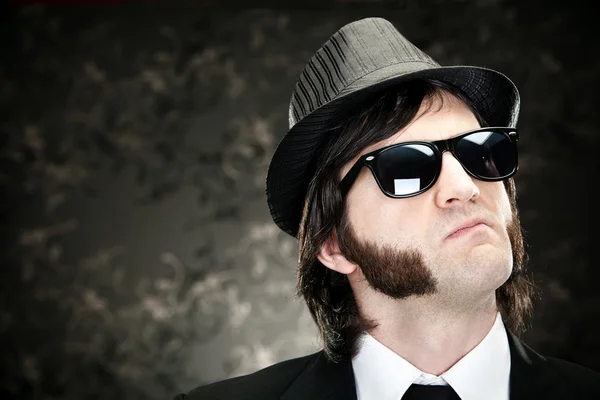 Elegante jefe hombre con patillas y gafas de sol en el fondo negro — Foto de Stock
