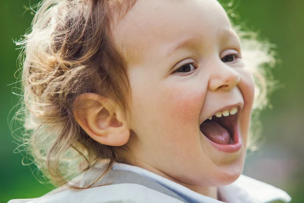 Hermoso rubio rizado pelo niño jugar al aire libre en un parque — Foto de Stock
