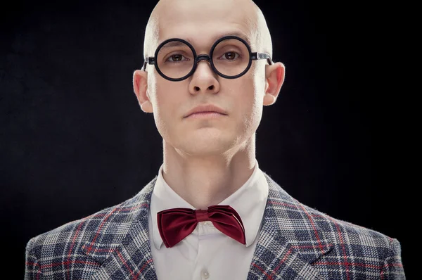 Junger kaukasischer Mann mit Glatze Professor oder Lehrer mit roter Fliege und Brille schwarz isoliert — Stockfoto