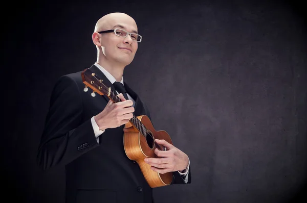 Jovem elegante sedutor homem com guitarra e óculos preto isolado — Fotografia de Stock