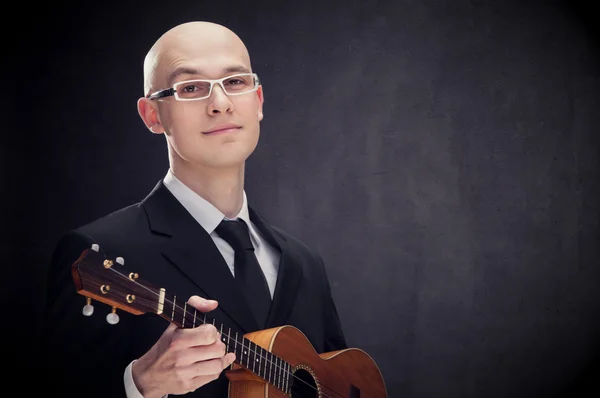 Jovem elegante sedutor homem com guitarra e óculos preto isolado — Fotografia de Stock