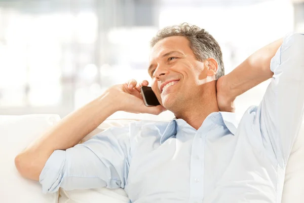 Bello sorridente uomo d'affari parlare al telefono in ufficio — Foto Stock