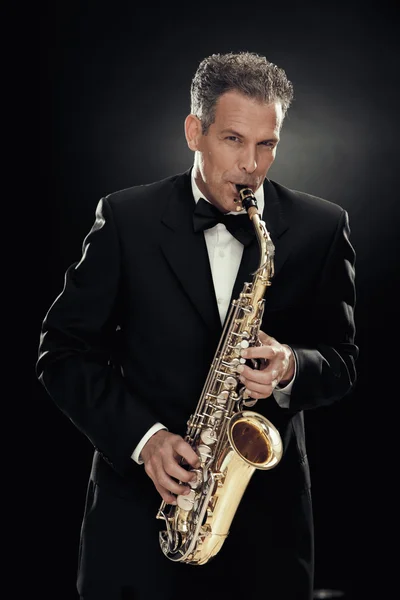 Knappe zakenman Speel saxofoon geïsoleerd op zwart — Stockfoto