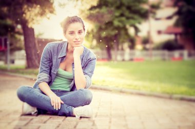 Gün batımında güzel kıvırcık kız bir Bahçe 