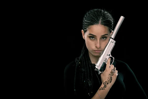 Bela mulher jovem pavor com arma retrato isolado em preto — Fotografia de Stock