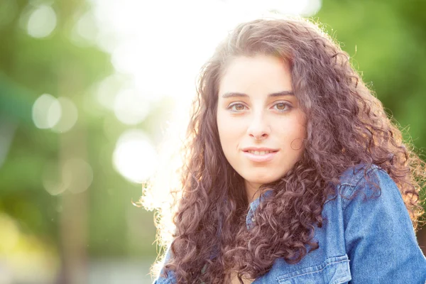 Hermoso retrato de niña rizada al atardecer en un jardín — Foto de Stock