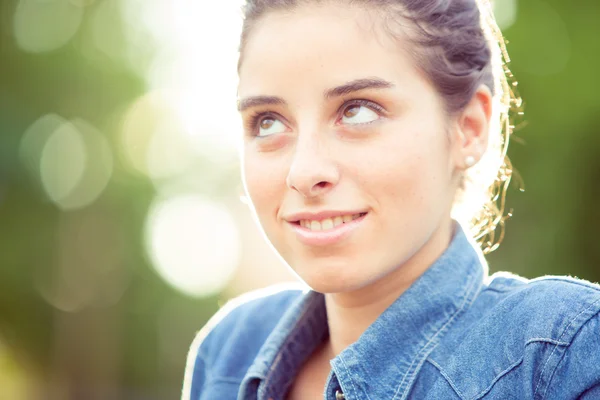 Mooi krullend meisje portret bij zonsondergang in een tuin — Stockfoto