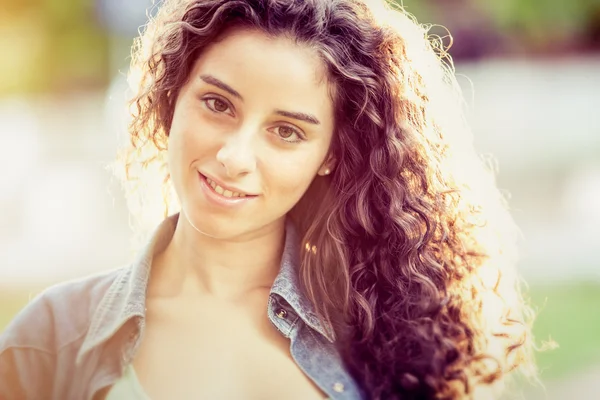 Beautiful curly girl portrait at sunset in a garden — Stock Photo, Image