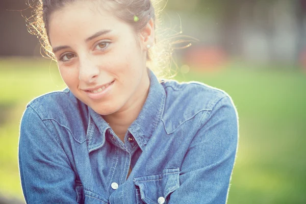 Hermoso retrato de niña rizada al atardecer en un jardín — Foto de Stock