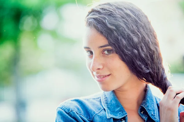 Mooi krullend meisje portret bij zonsondergang in een tuin — Stockfoto