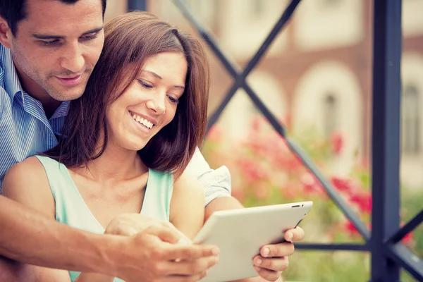 Joven morena pareja divirtiéndose junto con tableta en parque — Foto de Stock