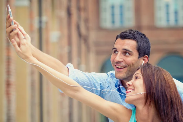 Jovem casal morena se divertindo junto com o smartphone no parque — Fotografia de Stock