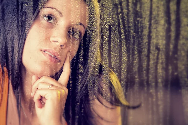Romantic young woman looks at rain through the window — Stock Photo, Image