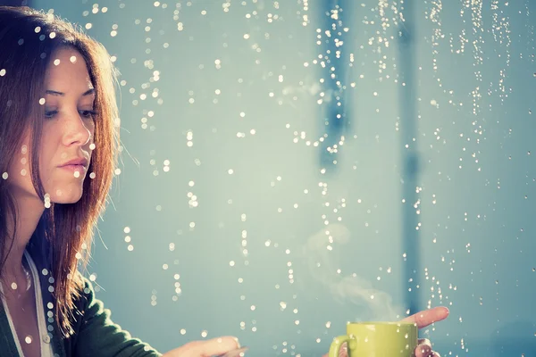 Romántica joven con taza de té mira a la lluvia a través de la ventana — Foto de Stock