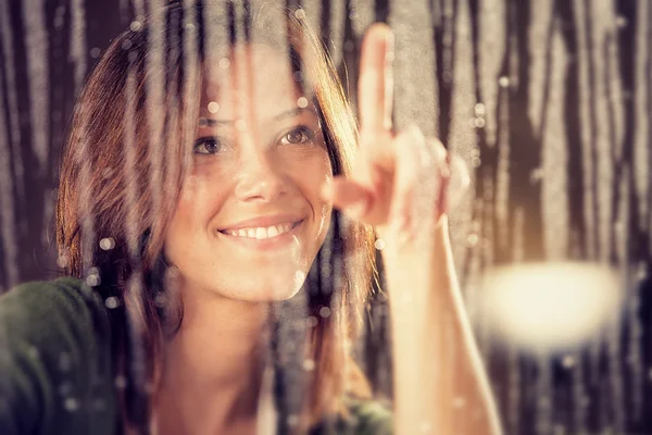 Romantic young woman looks at rain through the window — Stock Photo, Image