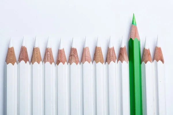 Crayon vert dépasser sur le concept de crayon blanc isolé sur blanc — Photo