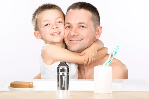 Усміхнена дитина чистить зуби з татом у ванній — стокове фото