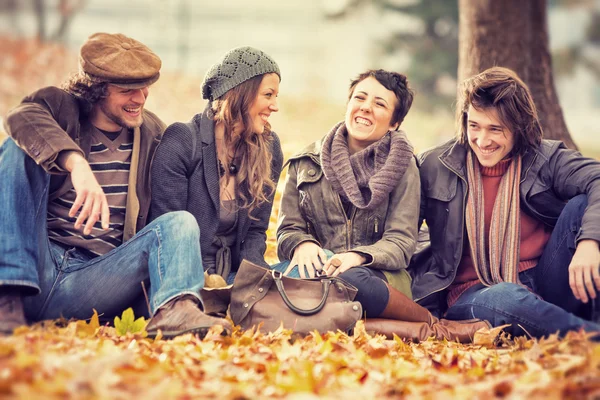 Kelompok Friends bersenang-senang di taman di musim gugur — Stok Foto