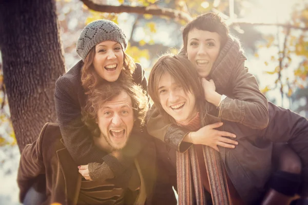 Grupa przyjaciół, zabawy w parku w jesieni — Zdjęcie stockowe