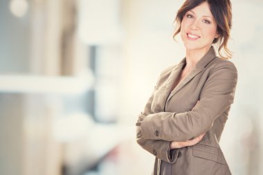 esmer genç iş kadını ofiste katlanmış silah ile gülümseyen