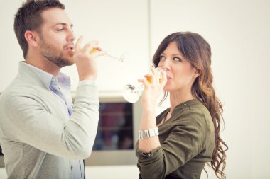 Şampanya ve mutfakta telefon ile genç casual çift alkış