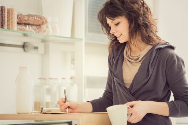 Mutfakta çay ile genç gülümseyen kadın