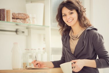 Mutfakta çay ile genç gülümseyen kadın