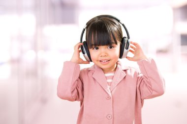 Küçük kız portre pink izole kulaklık ile gülümseyen Asya