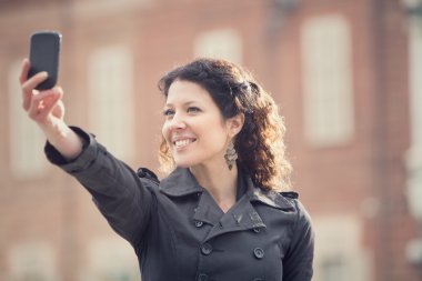 kısa saç gülümseyen kadın almak selfie cityscape içinde