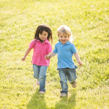Çift Interracial çocukların birlikte bir bahçede oyun