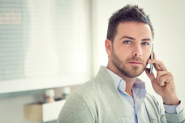 Súlyos fiatal üzletember alkalmi beszél a telefonon, iroda — Stock Fotó