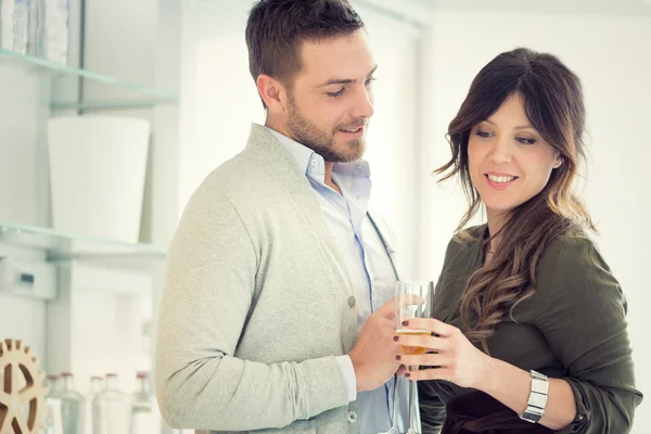 Junges lässiges Paar jubelt mit Champagner in der Küche — Stockfoto