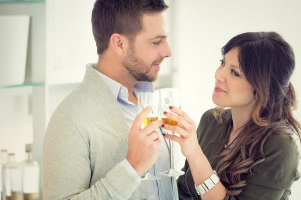Joven pareja casual vítores con champán en la cocina — Foto de Stock