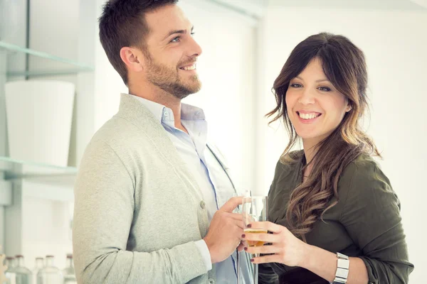 Junges lässiges Paar jubelt mit Champagner in der Küche — Stockfoto