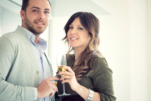 Junges lässiges Paar jubelt mit Champagner in der Küche — Stockfoto