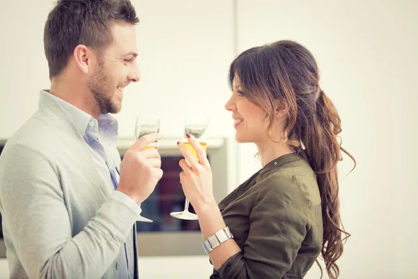 Junges lässiges Paar jubelt mit Champagner und Telefon in der Küche — Stockfoto