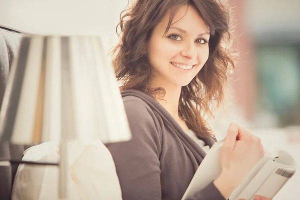 Junge lächelnde brünette Mädchen lesen in ihrem Schlafzimmer — Stockfoto