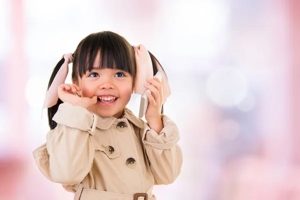 Asiatisk leende liten tjej prata i telefon isolerad på rosa — Stockfoto