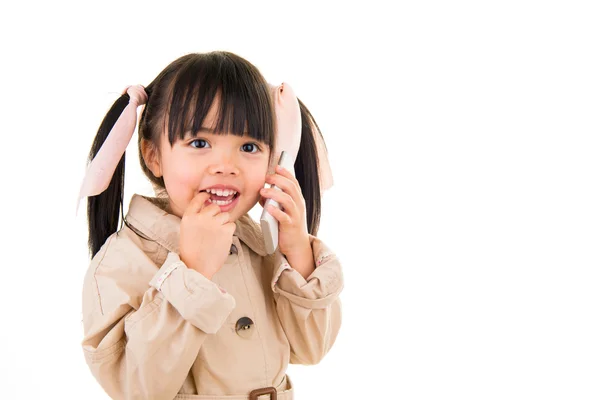 Азіатська усміхнена маленька дівчинка говорить по телефону ізольовано на білому — стокове фото