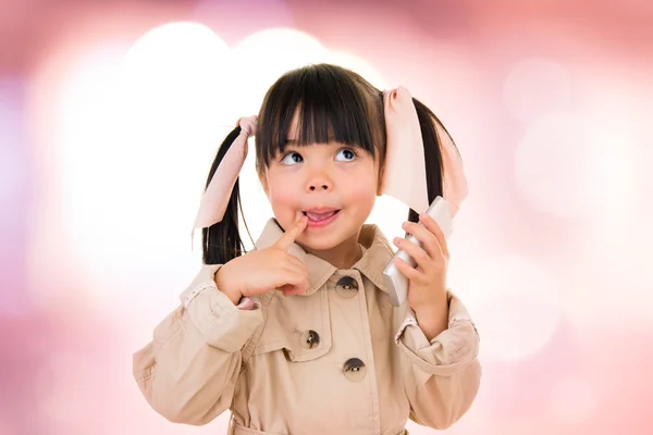 Asiatico sorridente bambina parlando su il telefono isolato su rosa — Foto Stock