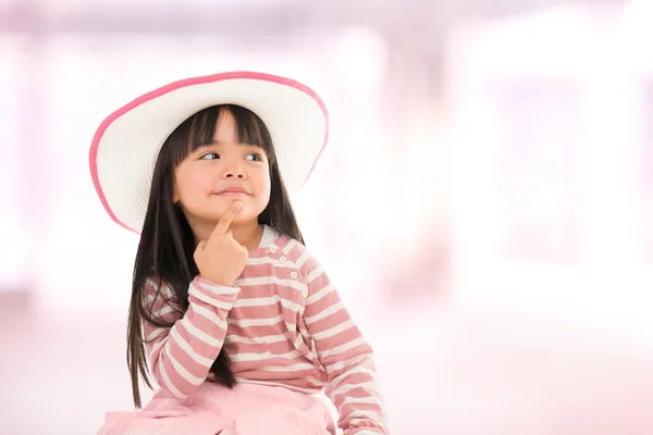 Aziatische lachende meisje met hoed op roze achtergrond — Stockfoto