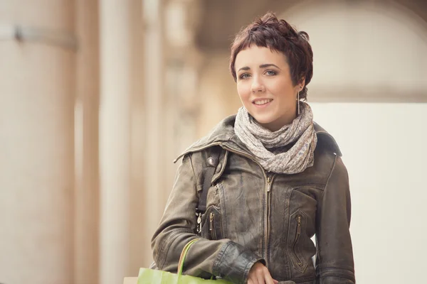 Kort haar lachende vrouw winkel in stadsgezicht — Stockfoto