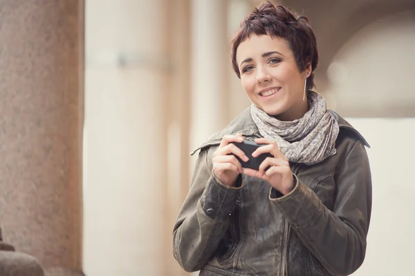 Păr scurt zâmbind femeie mers pe jos în peisaj urban — Fotografie, imagine de stoc