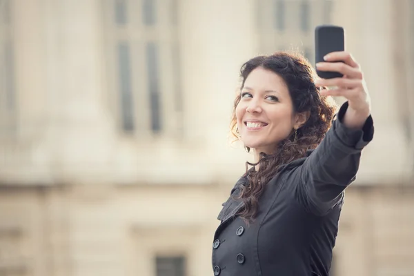 Kort haar lachende vrouw nemen selfie in stadsgezicht — Stockfoto