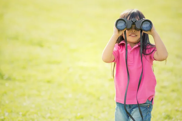 Feliz asiático sonriente niño jugar con binoculares en un jardín — Foto de Stock