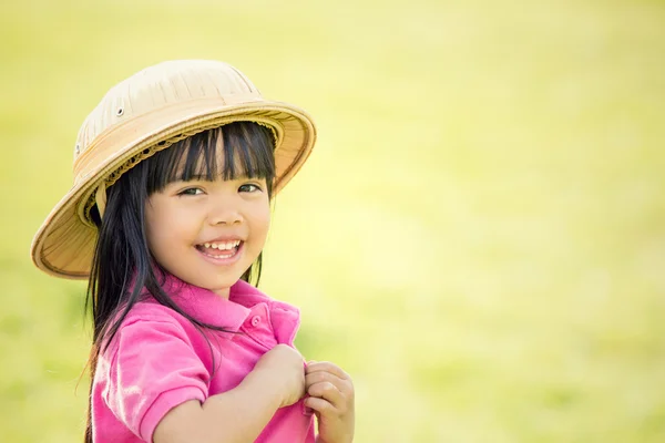 Счастливый улыбчивый ребенок в шляпе играет в саду — стоковое фото