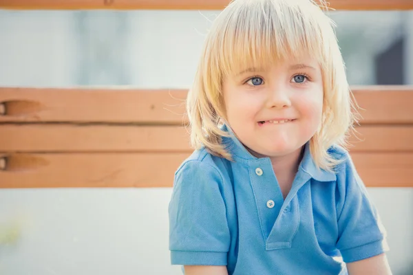 Glücklich lächelndes blondes Kind spielt im Park — Stockfoto