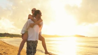 Genç Romantik Çift eğlenceli gün batımında kıyıda yazları açık var