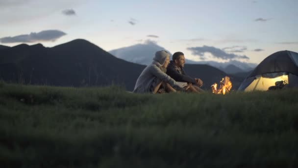 Grupo de tres amigos calentándose con fuego de campamento en la naturaleza montaña al aire libre — Vídeos de Stock