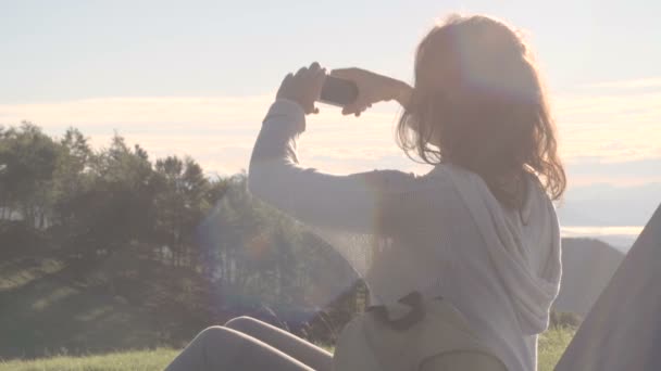 Young woman shooting a photo with smartphone in outdoor nature scenery — 비디오